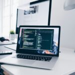 Laptop with lines of code on a busy desk, representing the technical choice between block and classic WordPress themes